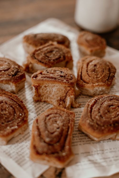 Free Close-up image of delicious cinnamon rolls on paper, perfect for breakfast or a sweet treat. Stock Photo
