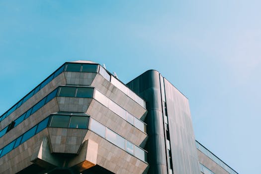 晴朗蓝天下，低角度拍摄的现代几何摩天大楼，展现了城市建筑的样貌