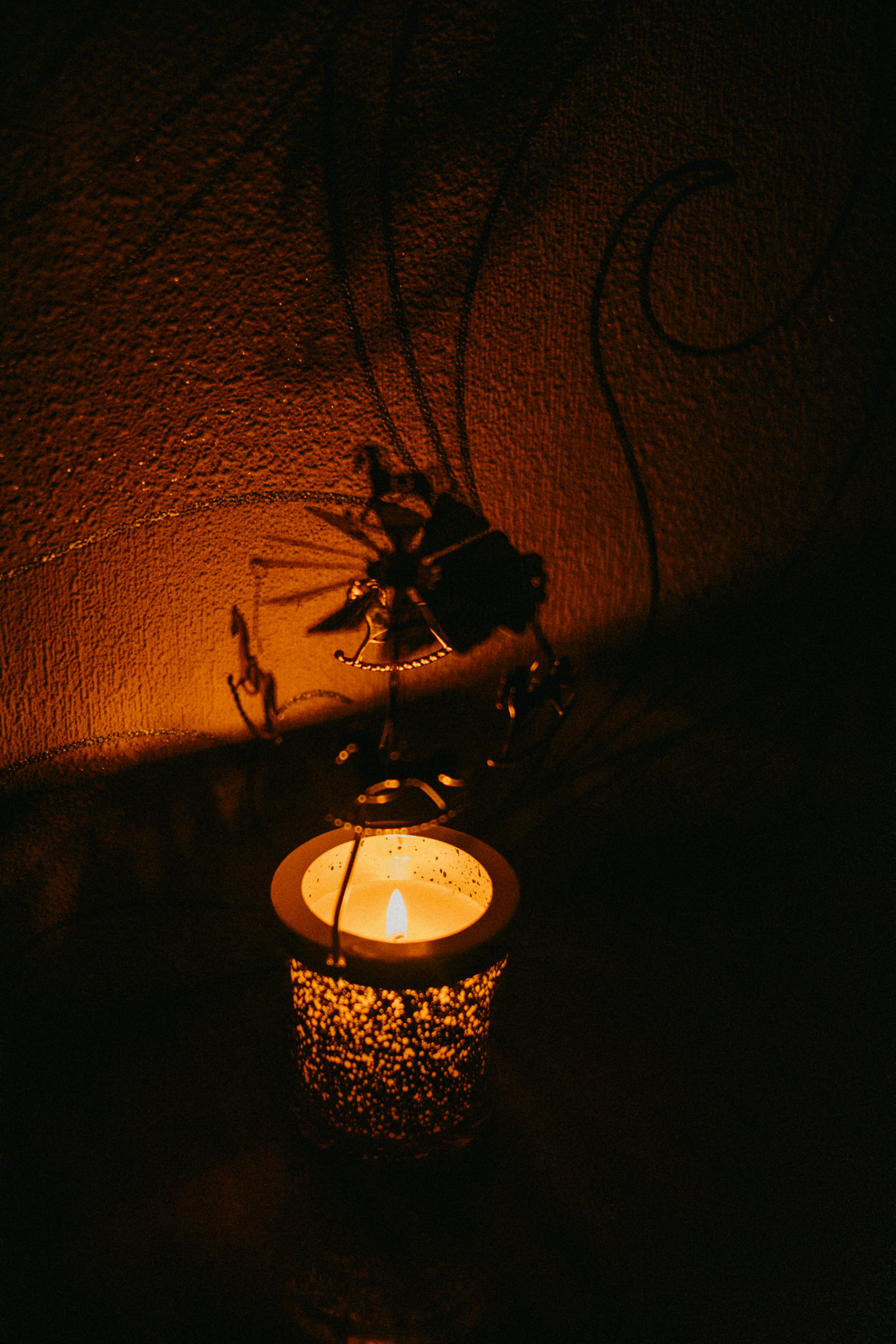 Warm candlelight casting artistic shadows on textured wall, intimate sensual atmosphere of slow hypnotic play
