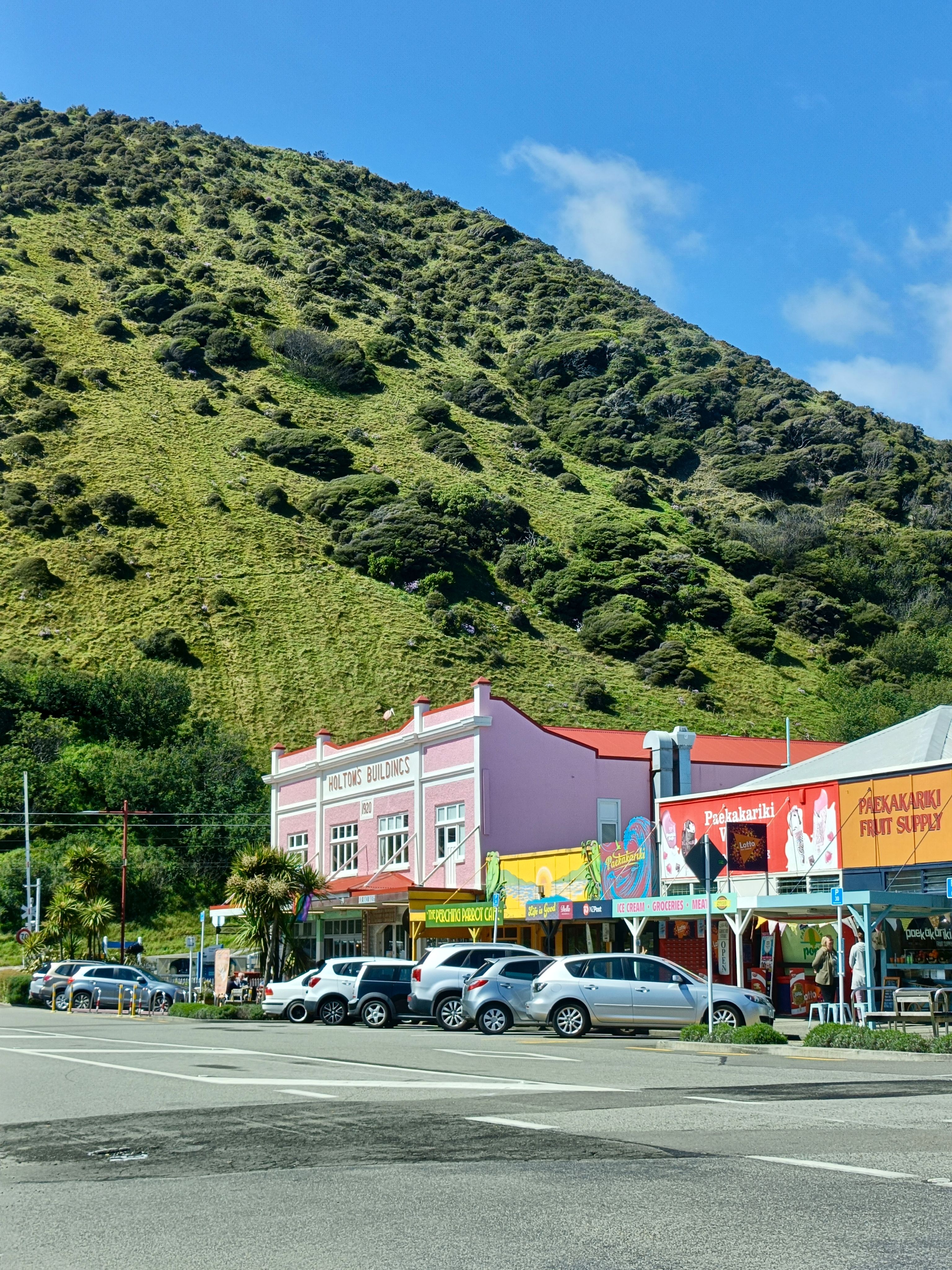 Explore colorful storefronts and lush hills in Paekākāriki, Wellington Region, New Zealand.