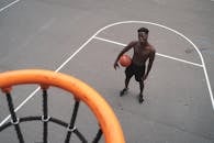 从鸟瞰视角看，篮球运动员在室外球场上持球