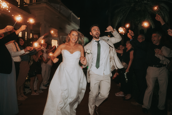 Couple celebrating with sparklers at a wedding send-off — representative image