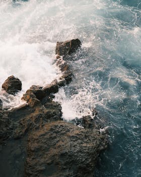 Waves crashing against a rugged rock formation, showcasing the raw power of nature.