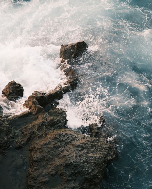 Waves crashing against a rugged rock formation, showcasing the raw power of nature.