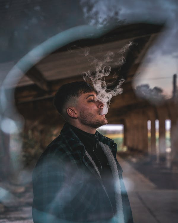 Selective Focus Photo of Man Vaping