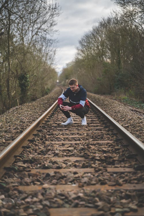 Man Crouching on Train Rails