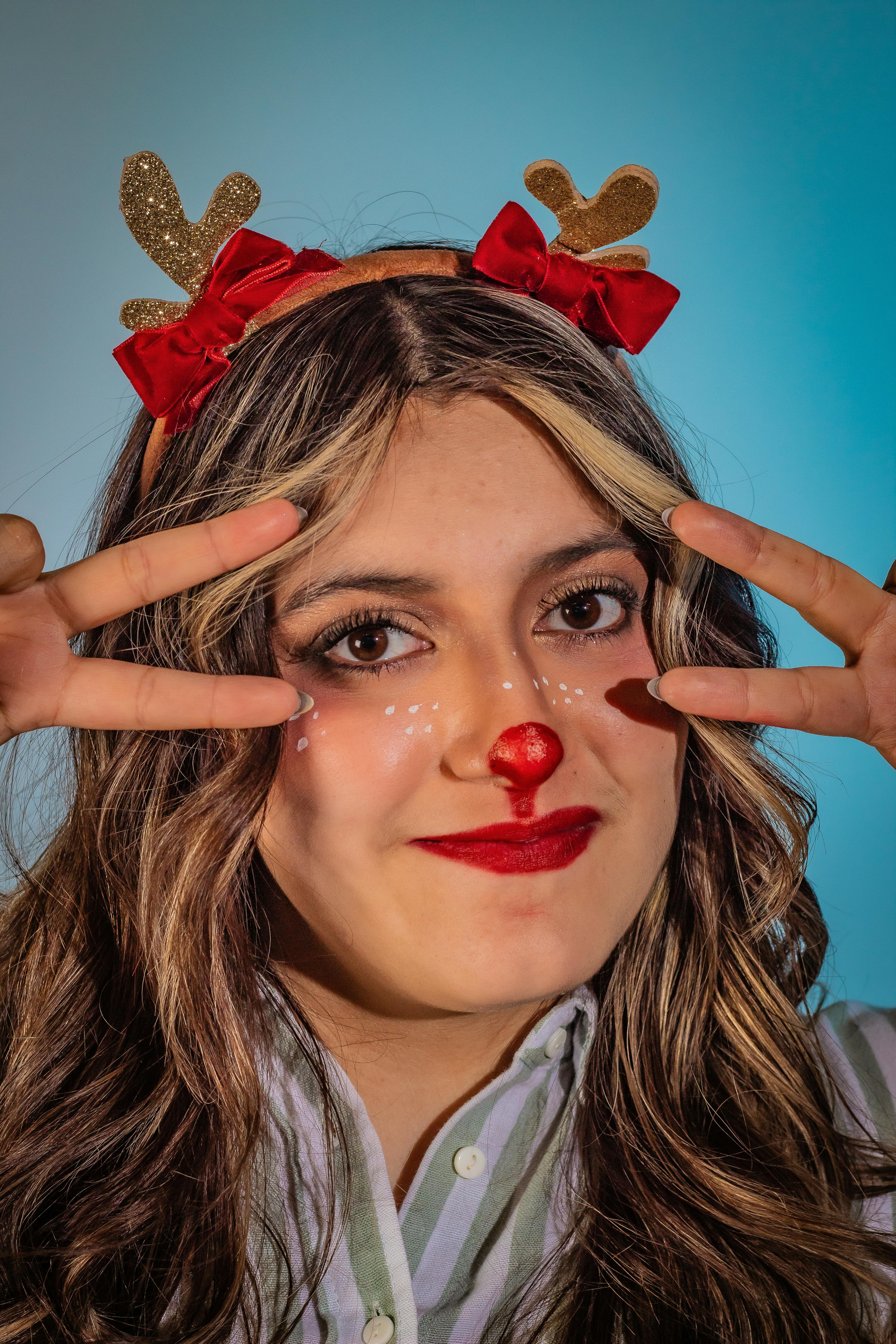 De franc Dona amb una diadema de banya de ren amb la postura del signe de la pau, somrient. Foto d'estoc