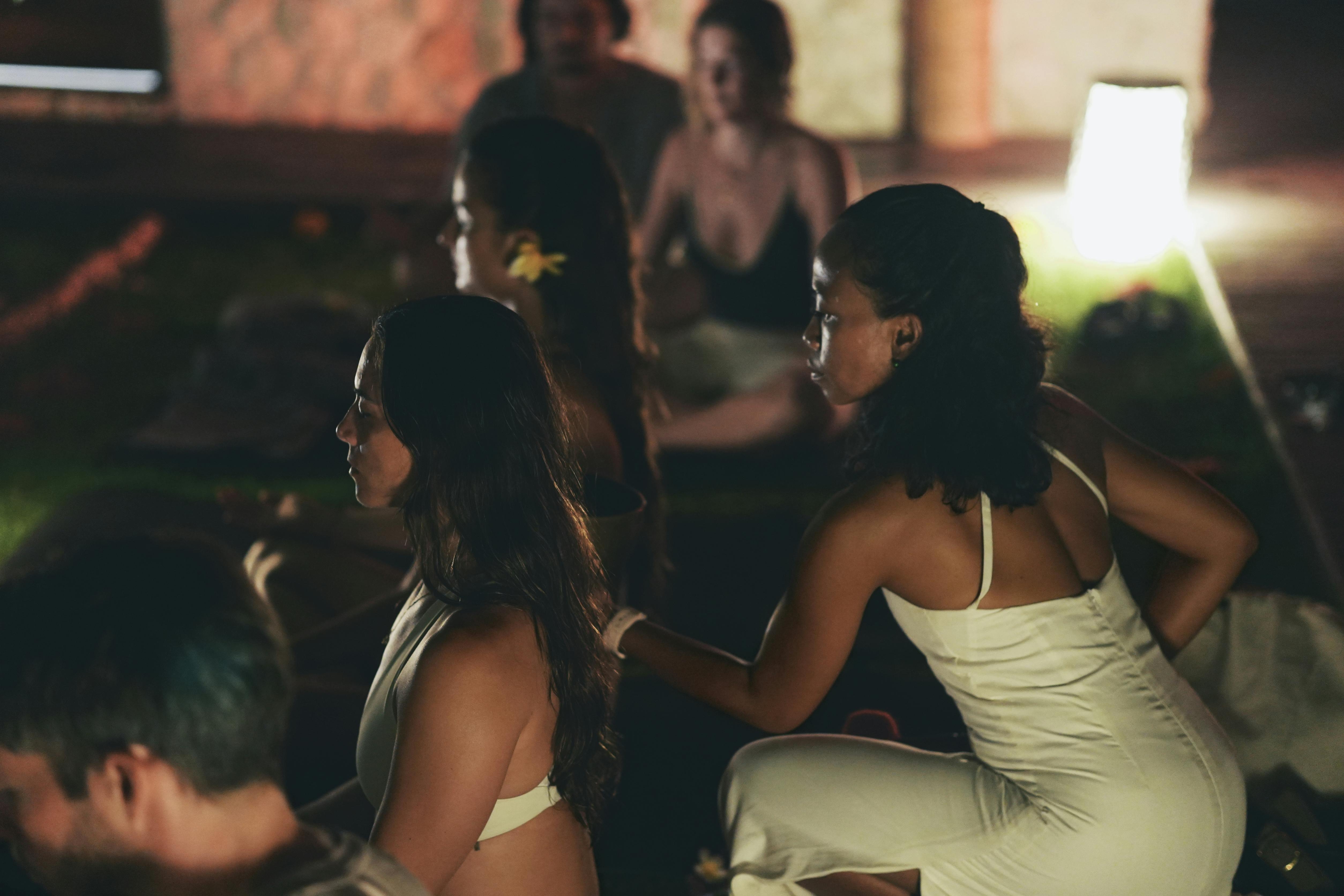 A serene group meditation session by candlelight indoors promoting relaxation and mindfulness.