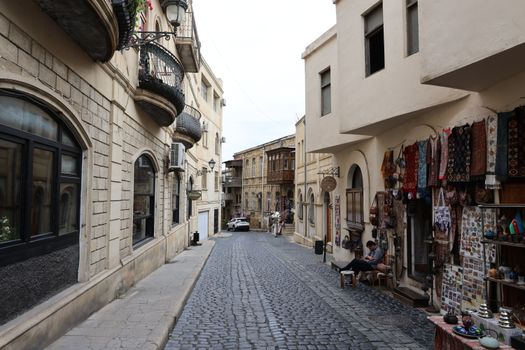 Explore a quaint cobblestone street lined with traditional architecture and market stalls in an old town setting.