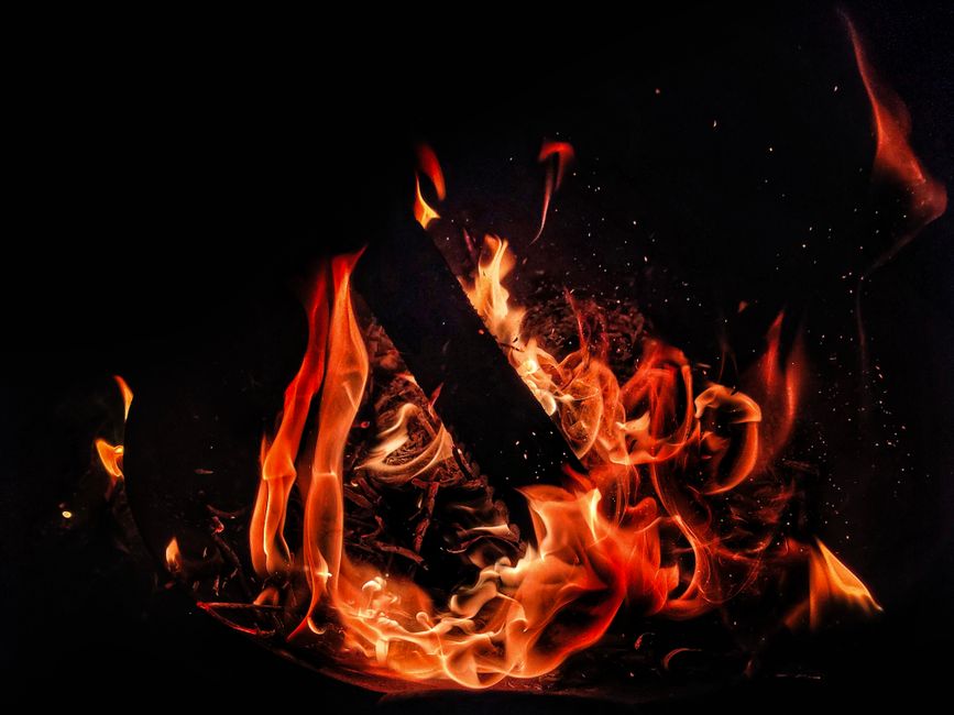 Dynamic image of flames against a black background, capturing fiery waves and contrast.