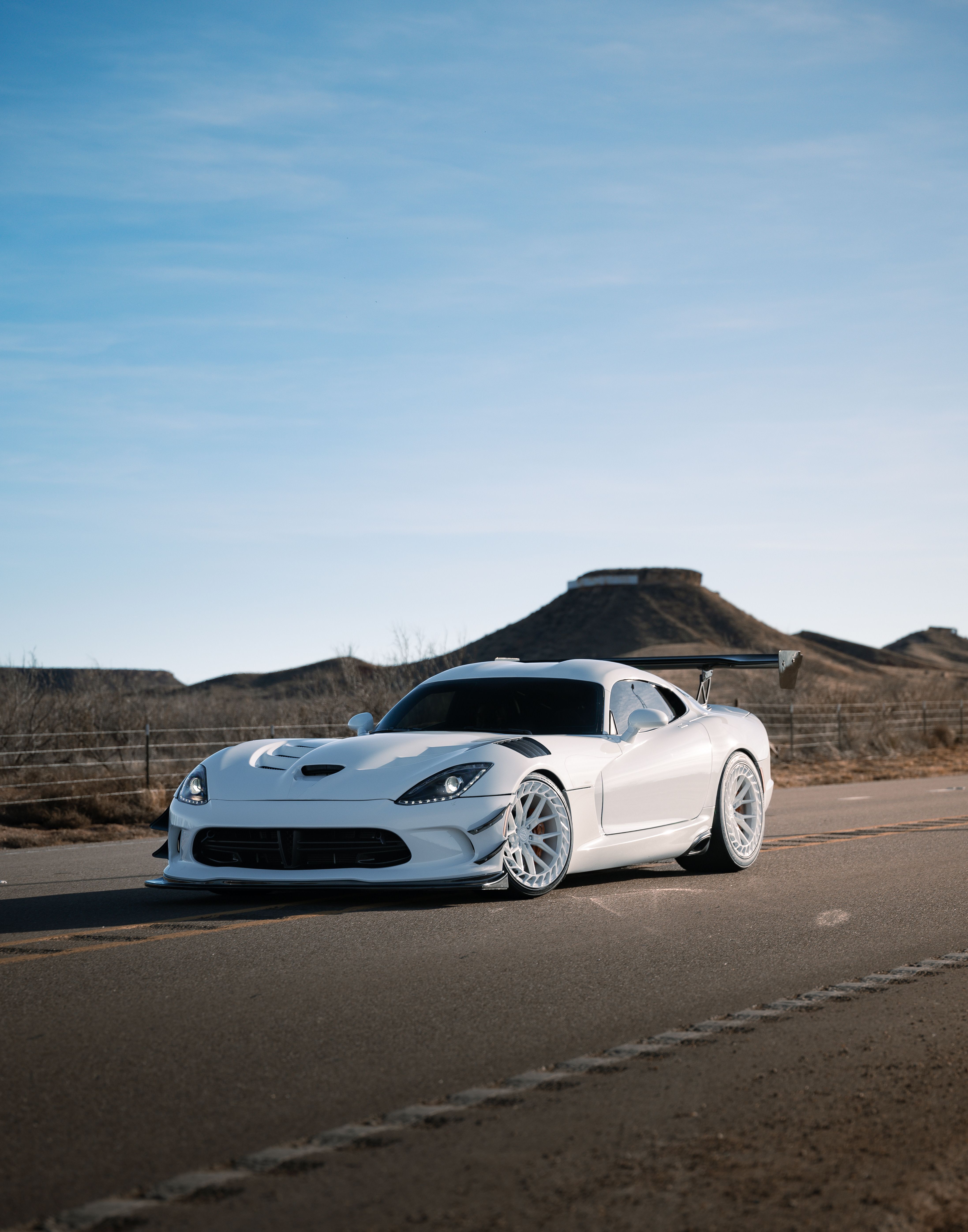 Sleek White Sports Car on Scenic Highway · Free Stock Photo