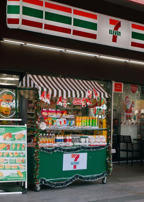 Free 7-Eleven store with vibrant Christmas decorations and festive snacks on display. Stock Photo