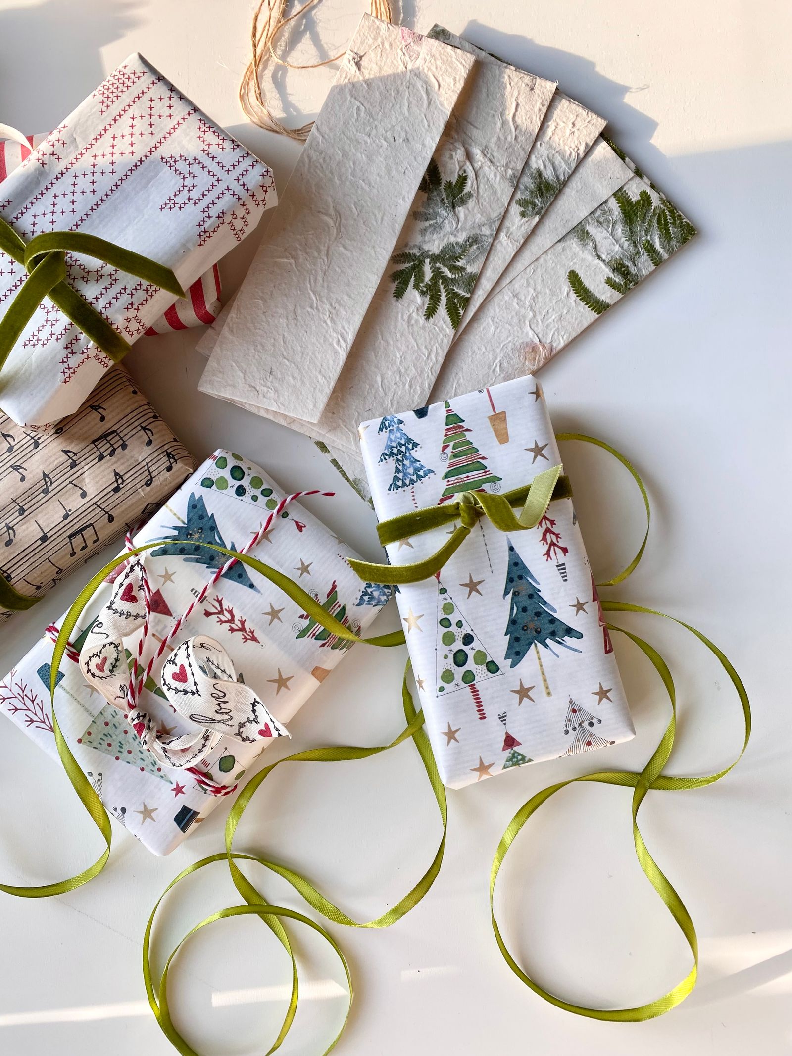 Illustrative Christmas gift wrapping scene with green ribbons and festive paper arranged on a wooden surface