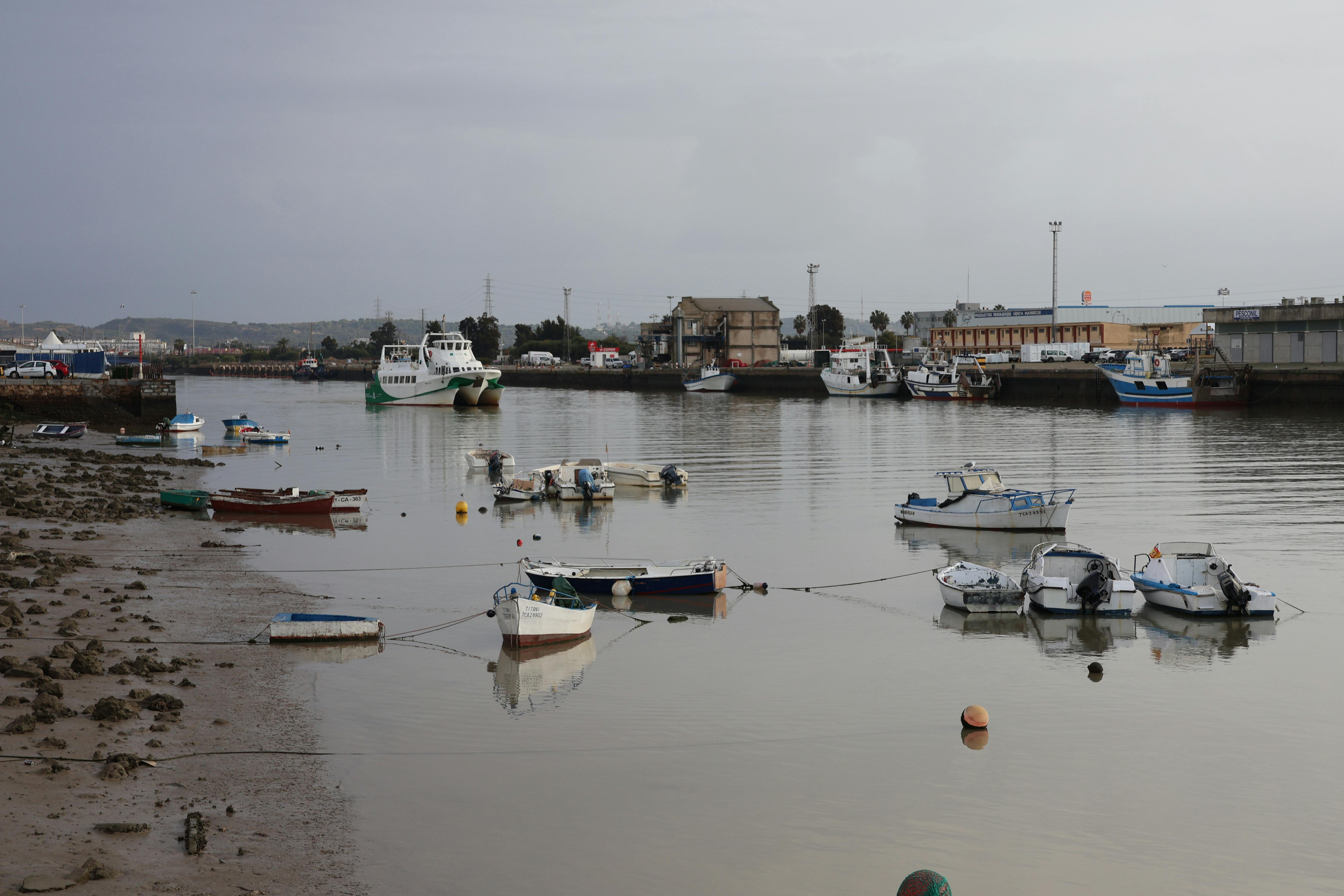 Tranquil scene of boats moored on a calm river in El Puerto de Santa María, Spain.