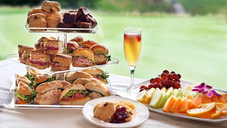 A Variety Of Sandwiches And Fruits On Table