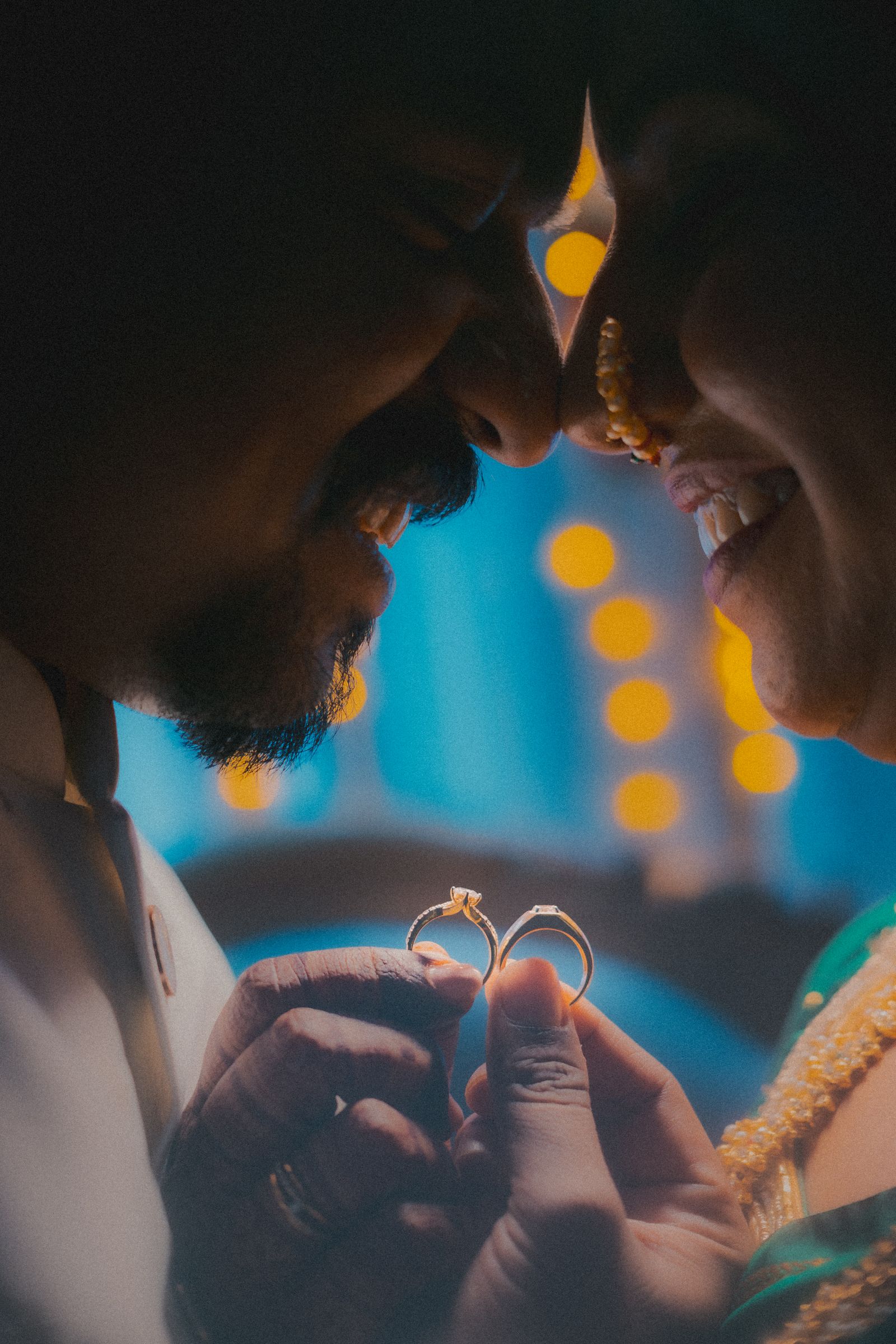 Couple joyfully holding rings, symbolizing love and engagement