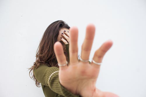 Photo of a Woman Covering Her Face with Her Hand