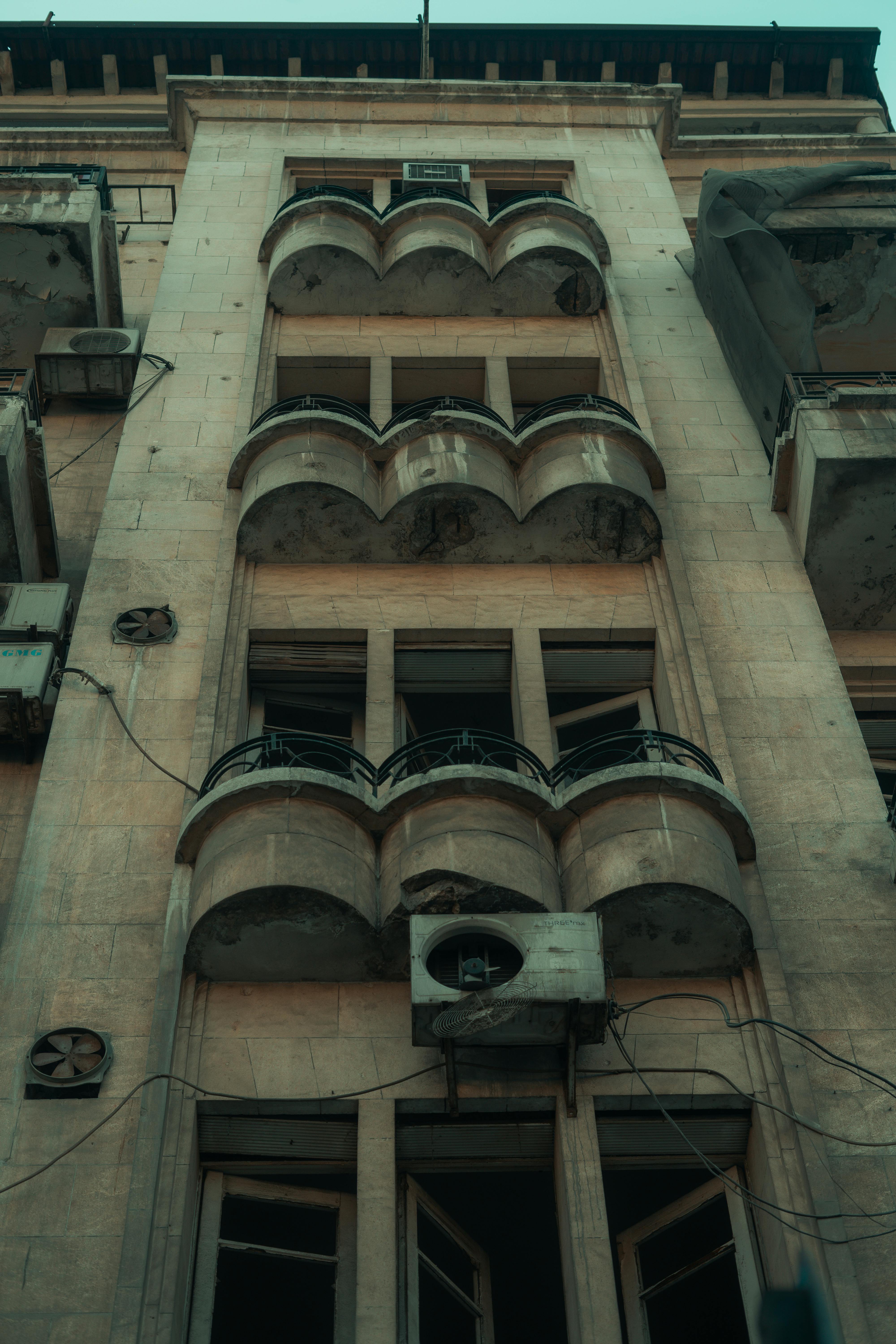 Close-up of a vintage building facade featuring multiple air conditioning units and architectural details.