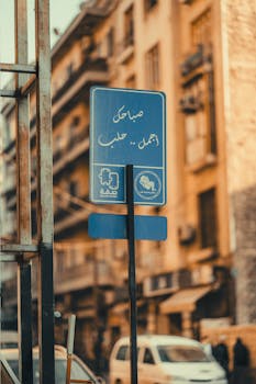 Street sign in urban environment with historic buildings in background.