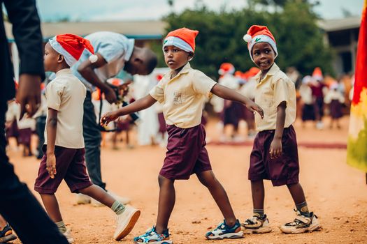 Group of children with Santa hats enjoying a festive outdoor event.