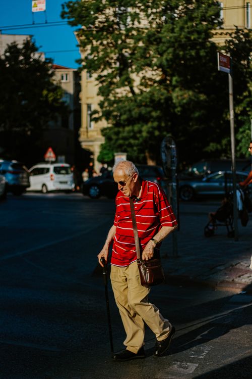Free An elderly man with a cane crosses a sunlit street in Istanbul, Türkiye. Stock Photo
