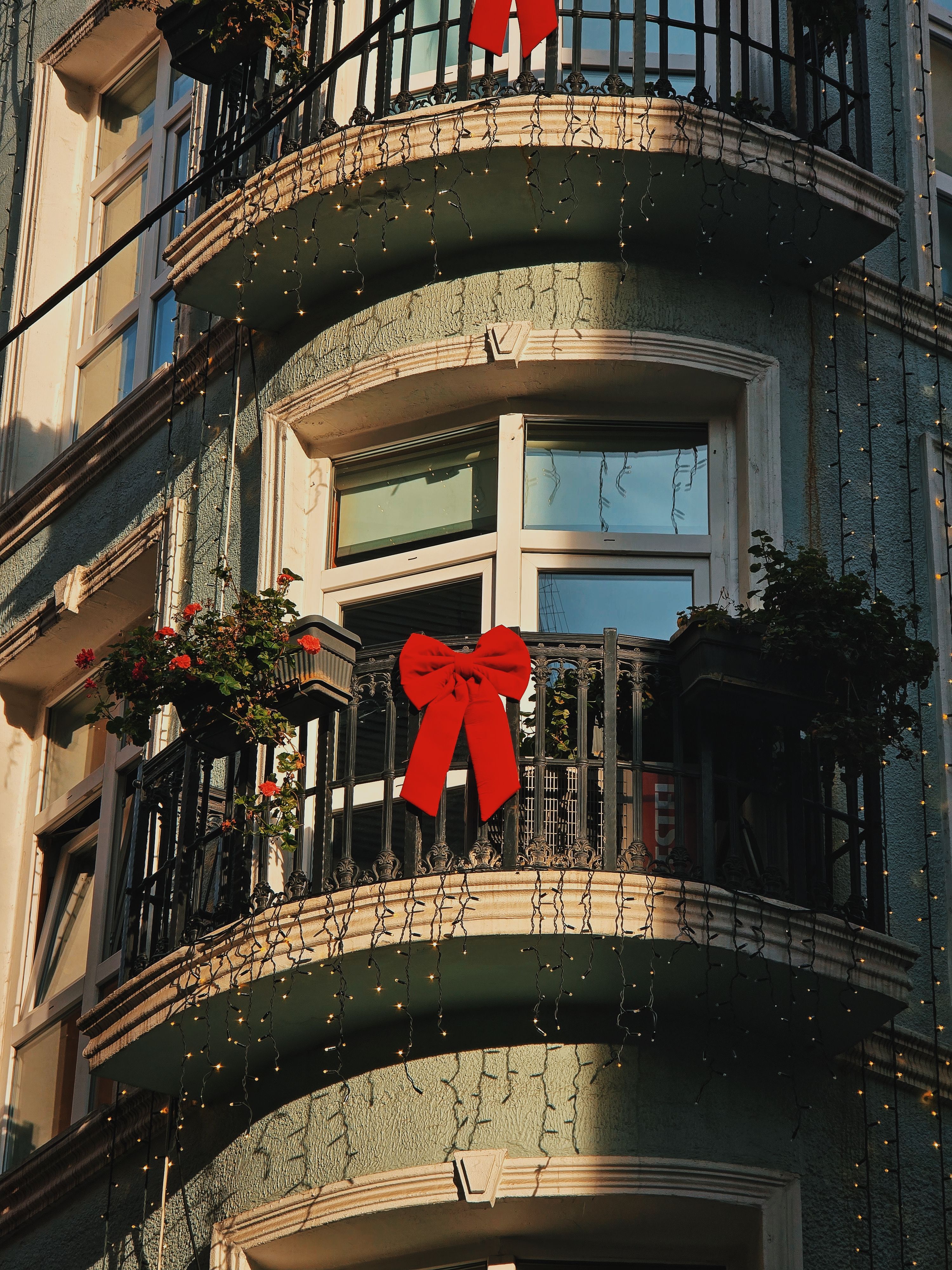 Charming balcony with festive red bows and lighting, perfect for holiday decor inspiration.