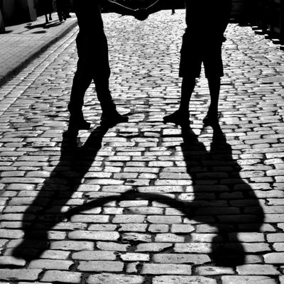 Long shadows of two people on a cobbled street, photo by Alexander Zvir on Pexels