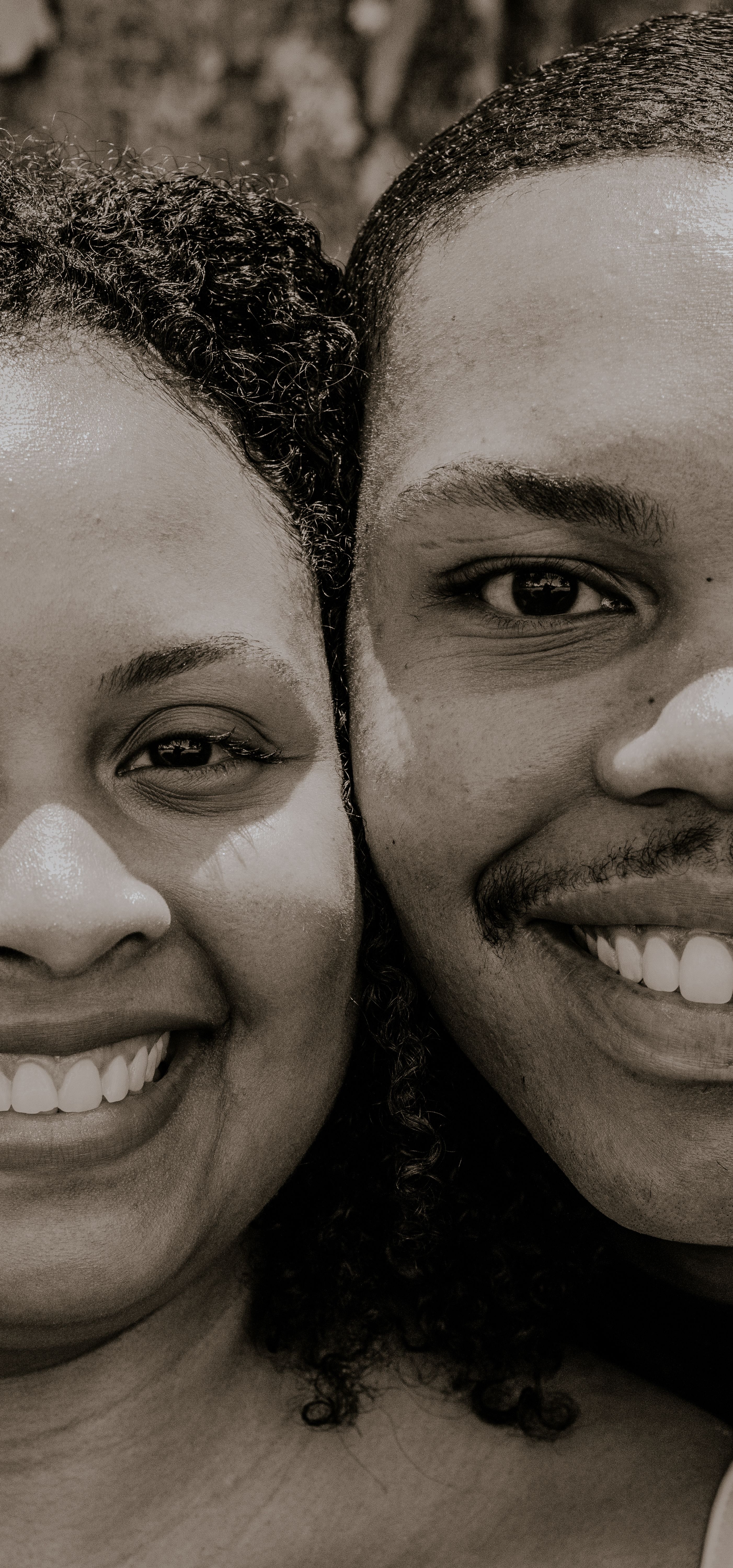 Black and white close-up of a happy couple smiling, showcasing joy and connection.