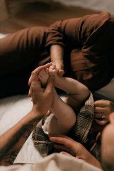 Intimate family moment showing a parent holding a baby's feet with love and care.