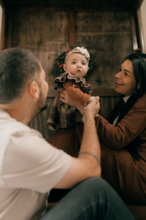 Free A joyful family moment captured indoors featuring parents holding their baby with love. Stock Photo