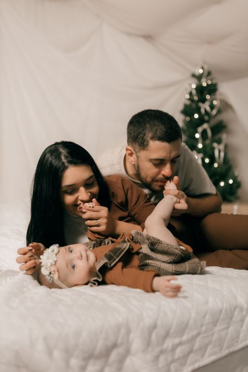 Free A young couple with their baby enjoying a cozy Christmas at home. Stock Photo