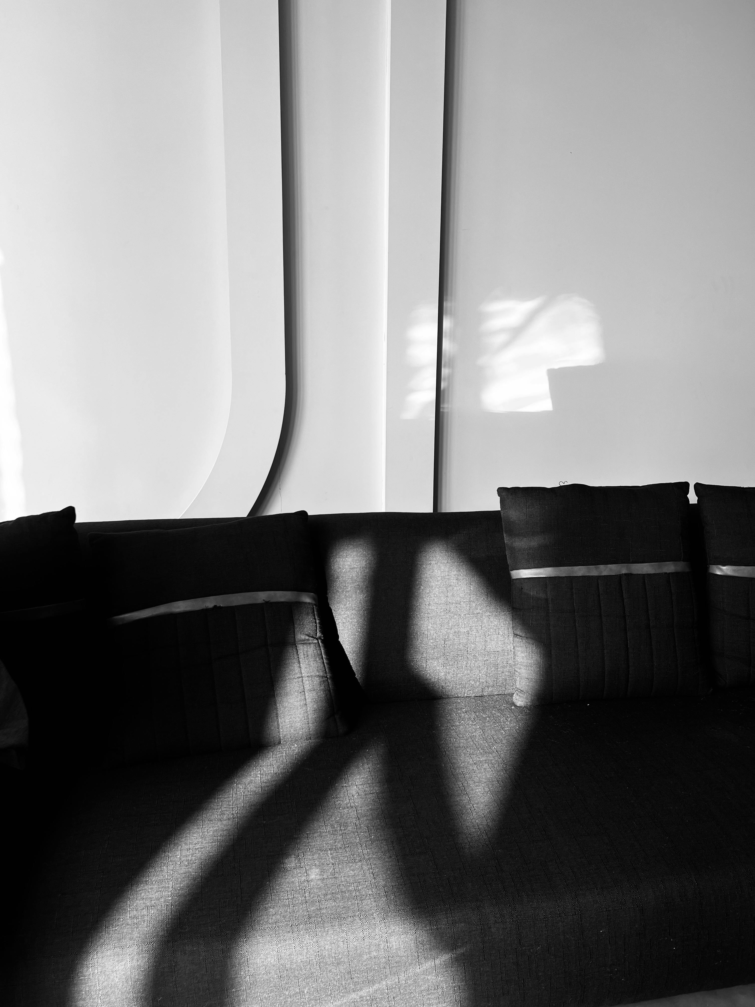 De franc Interior elegant en blanc i negre amb la llum del sol projectant ombres dramàtiques sobre un sofà al Pakistan. Foto d'estoc