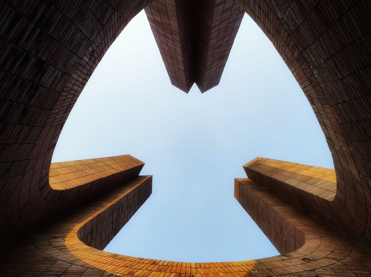 upward view of modern brick architecture with blue sky background