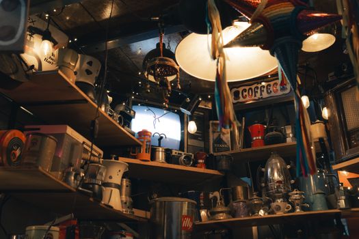 A cozy cafe featuring vintage decor with antique coffee makers and string lights creating a warm atmosphere.