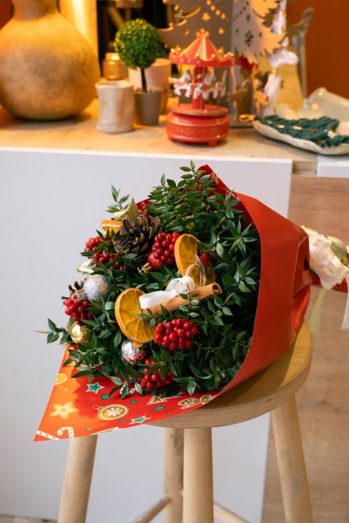 Free A vibrant Christmas bouquet with berries and ornaments on a stool indoors. Stock Photo