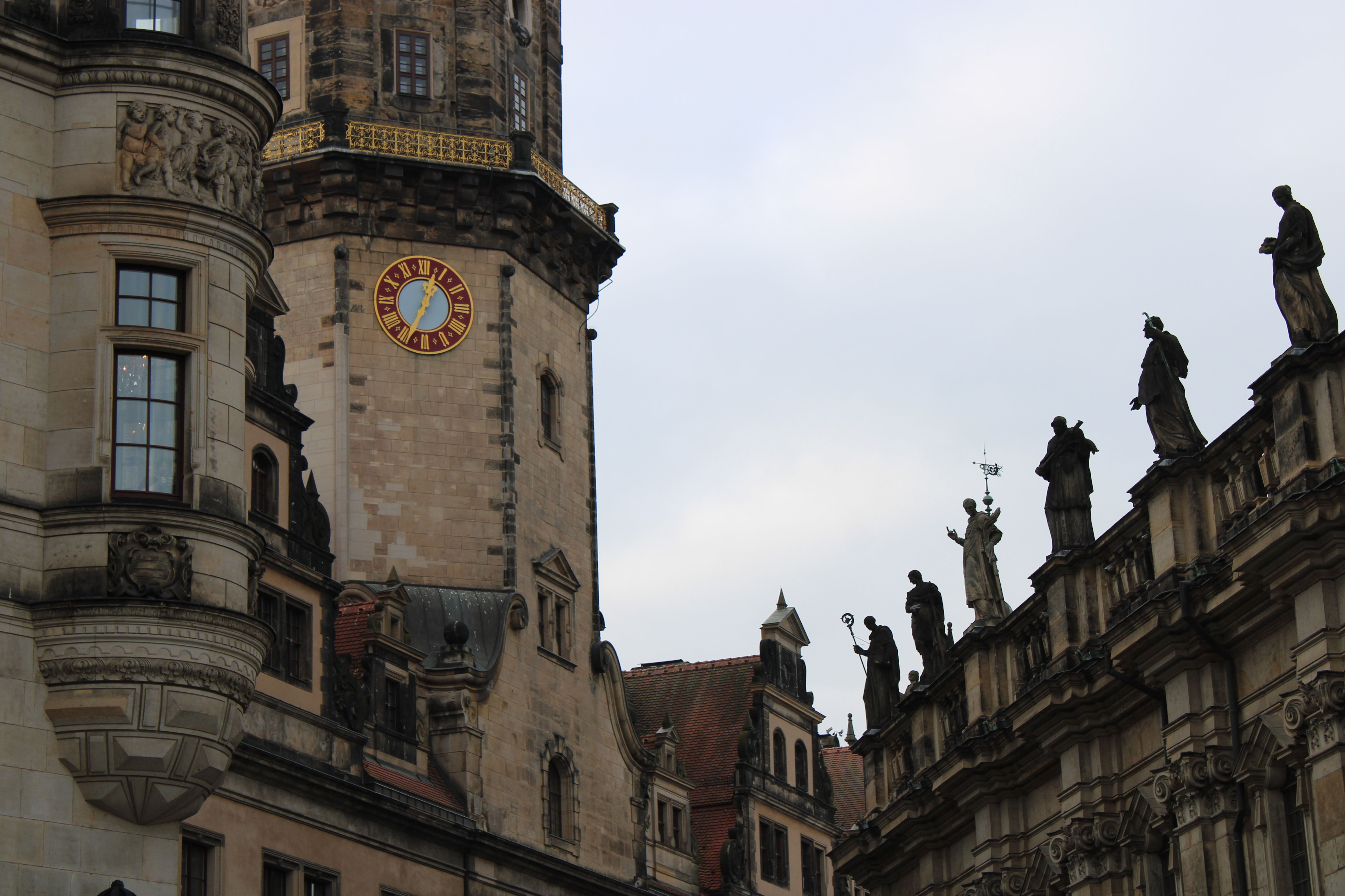 The intricate architecture of Dresden Castle with the Cathedral's statues lined along the rooftop.
