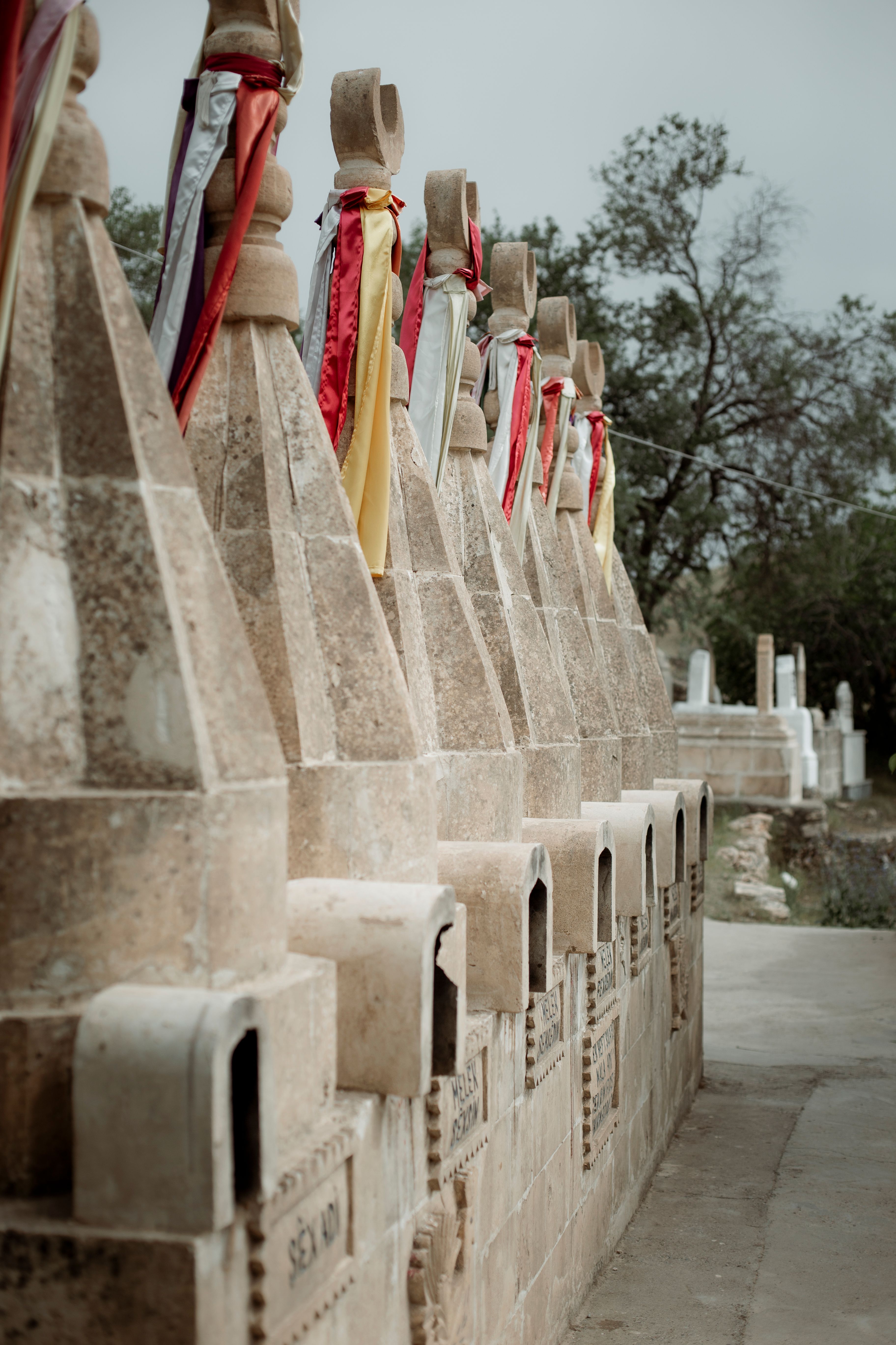 Historic tombstones adorned with colorful fabric in Idil, Şırnak, Türkiye.