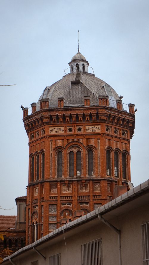 Free Red brick tower with intricate architecture set against a cloudy sky, exuding historic charm. Stock Photo