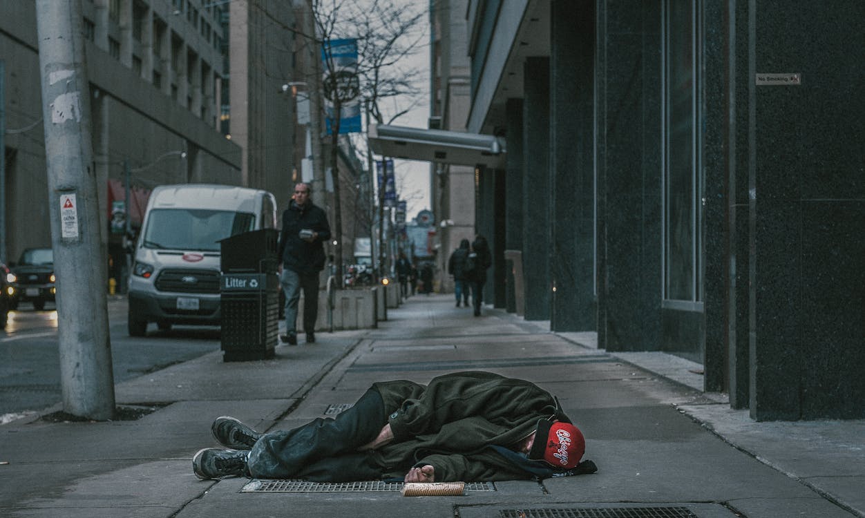Photo Of Man Laying On Sidewalk