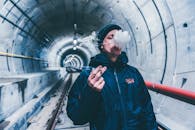 一名男子在城市地下隧道里抽烟，烟雾滚滚