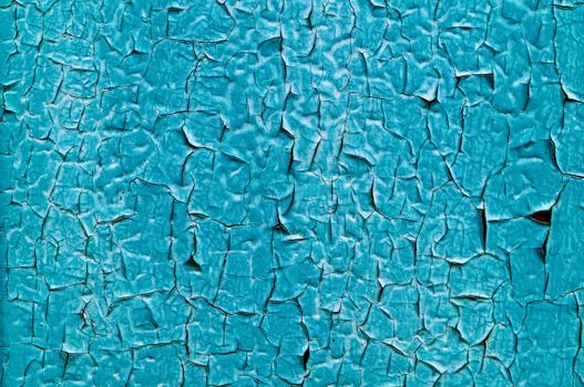 Detailed image of cracked turquoise paint creating a unique abstract texture.