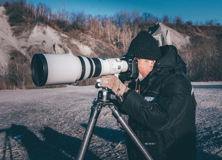 Man Taking Picture Using A Camera With Telephoto Lens