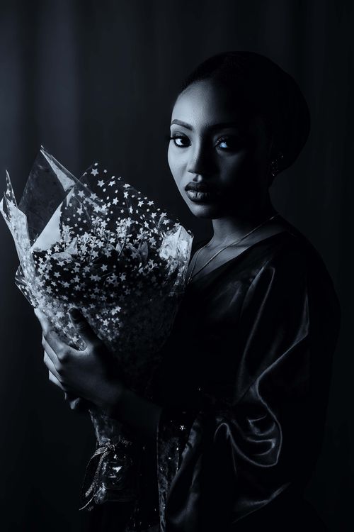 Free A dramatic portrait of a woman with a bouquet, in a sophisticated and moody setting. Stock Photo