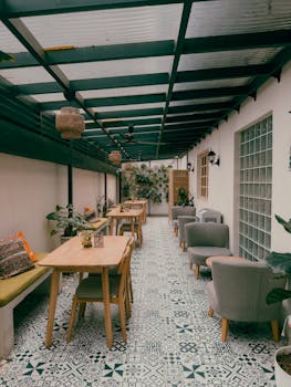 A modern outdoor patio featuring stylish furniture and lush plants in a chic setting.