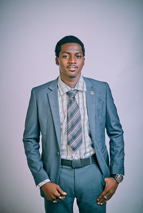 Free Confident young man wearing suit and tie, standing with hands in pockets, exuding professionalism. Stock Photo