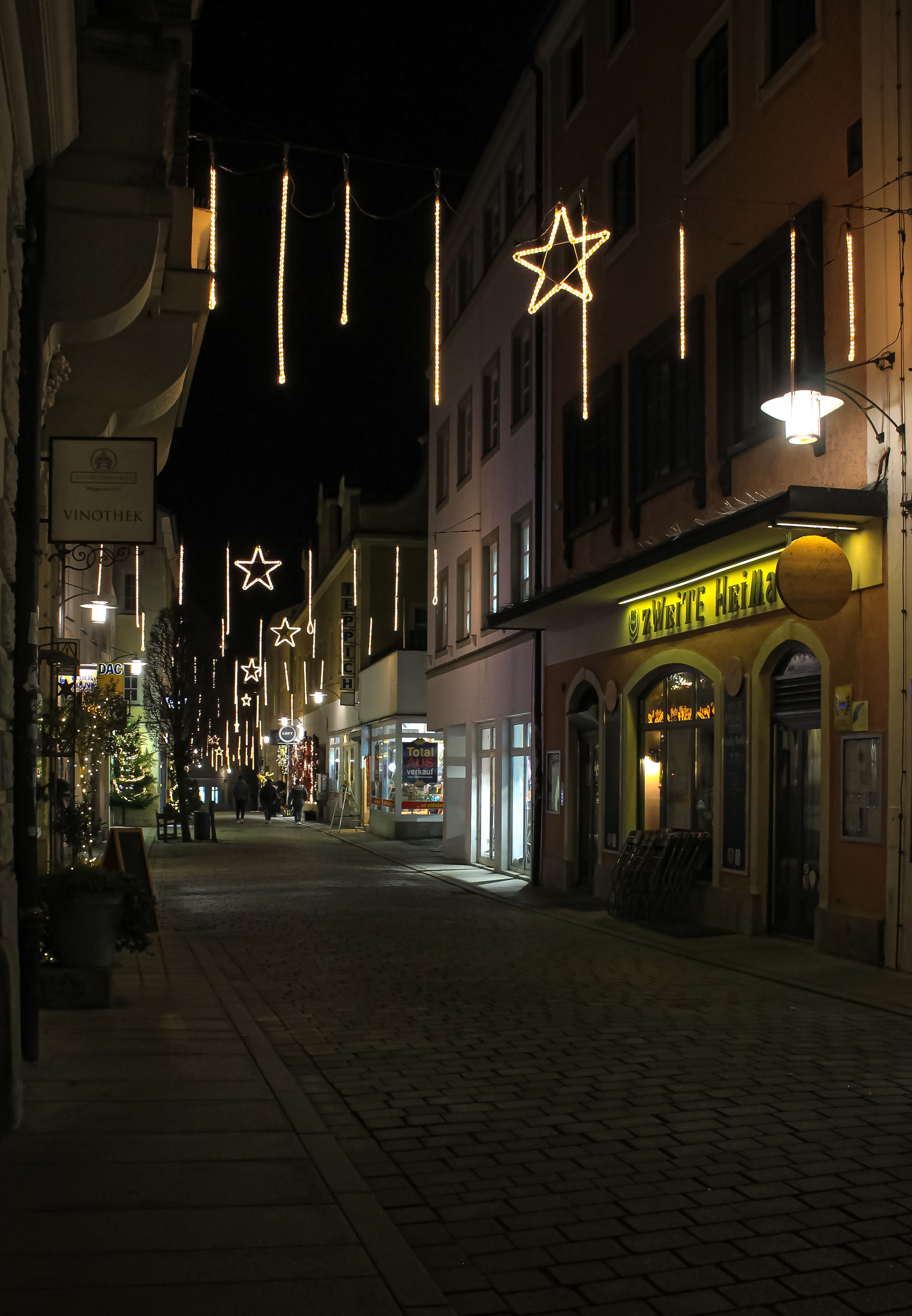 Enchanting night street scene adorned with glowing festive lights and decorations.