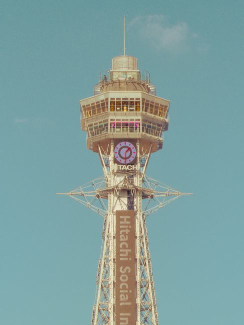 Vintage-style image of Tsutenkaku Tower, Osaka, with a clear blue sky background.