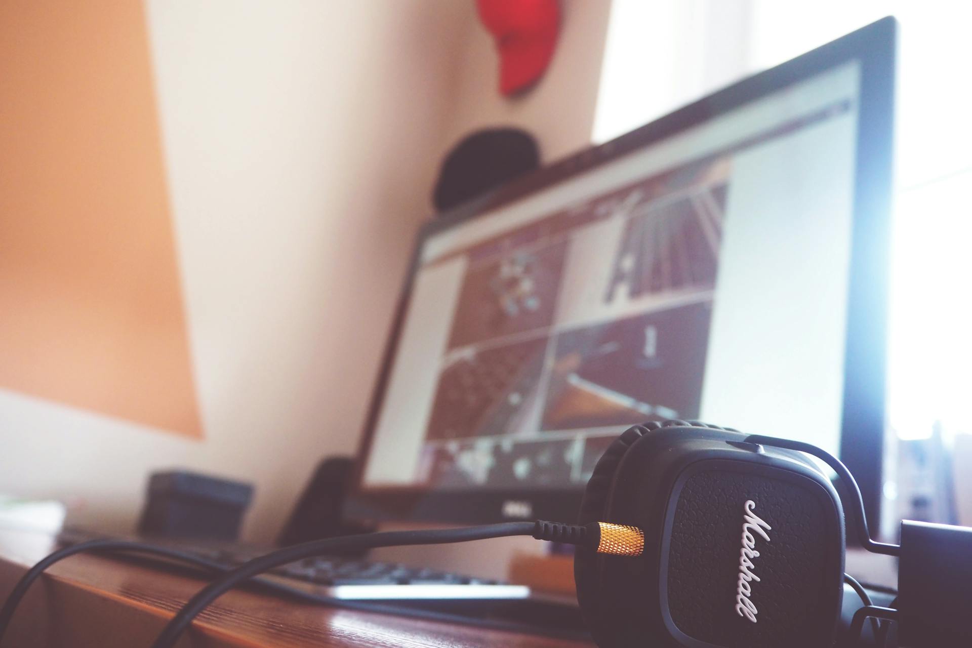 A contemporary desk setup featuring headphones and a computer screen displaying digital content.