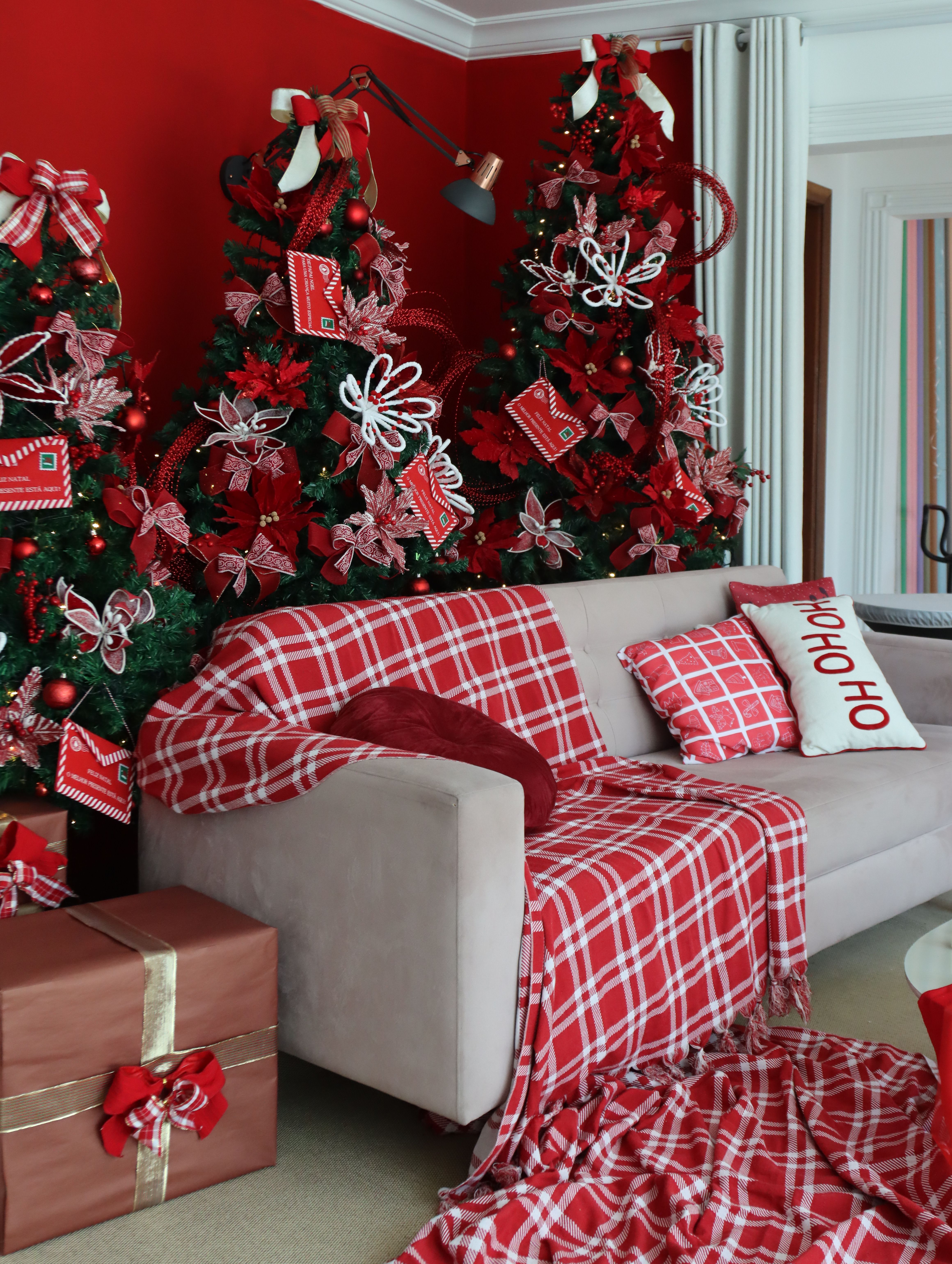 Sofa layered with a red plaid Christmas throw and festive cushions