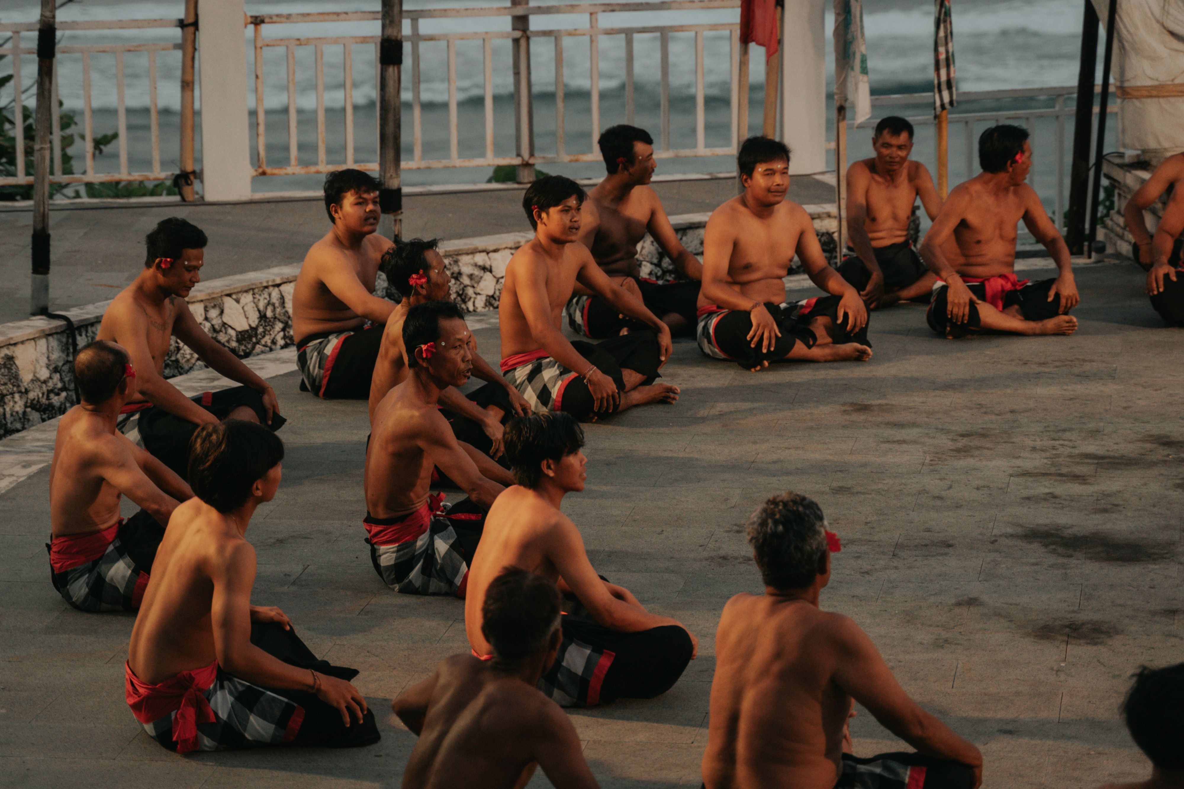 Group of men performing the traditional Kecak dance in Bali, Indonesia, wearing traditional attire.